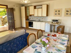 eine Küche und ein Esszimmer mit einem Tisch mit Blumen darauf in der Unterkunft Torre Ferienwohnung mit Garten in San Siro