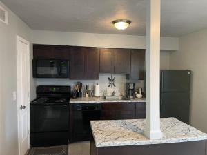 a kitchen with wooden cabinets and a black appliances at 2Bdrm Comfortable Townhome 5 Mins from Airport in Atlanta