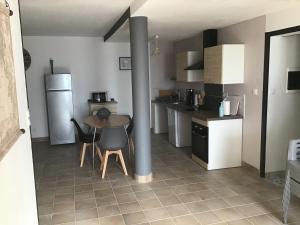 a small kitchen with a table and a refrigerator at Le petit Lambertie in Vergt
