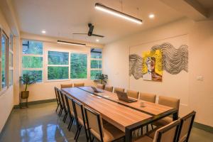 a dining room with a large wooden table and chairs at Zostel Kasol, Katagla in Kasol +69 photos