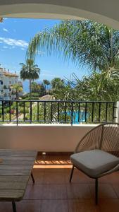 einen Balkon mit einer Bank und Meerblick in der Unterkunft La Palmera - Amazing apartment with excellent location & views in Marbella