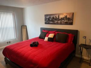 a cat laying on a red bed in a bedroom at 2Bdrm Comfortable Townhome 5 Mins from Airport in Atlanta