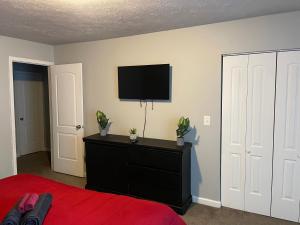 a bedroom with a bed and a flat screen tv at 2Bdrm Comfortable Townhome 5 Mins from Airport in Atlanta