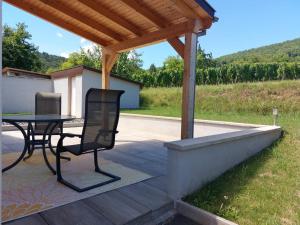 eine Terrasse mit einem Tisch und Stühlen unter einem Dach in der Unterkunft Entre Histoire et Terroir - 2 Gîtes de Charme in Kintzheim