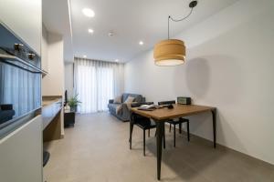 sala de estar con mesa y sofá en Alidreams Lola Center Apartamentos, en Alicante