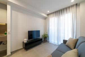 sala de estar con sofá azul y TV en Alidreams Lola Center Apartamentos en Alicante