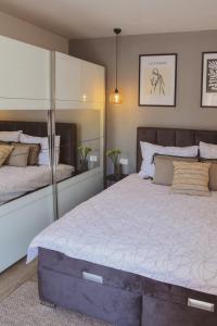 a bedroom with a large bed and a mirror at Apartment Andrija in Šibenik
