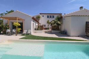 a house with a swimming pool in front of a house at Le mas Sainte Marie in Venasque