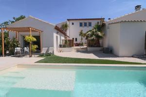 a house with a swimming pool in front of a house at Le mas Sainte Marie in Venasque