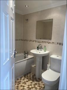 La salle de bains est pourvue d'un lavabo, de toilettes et d'une baignoire. dans l'établissement Yew Tree Court, à Heswall