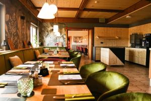 a restaurant with long tables and green chairs at DAS PALMBERGER in Spiegelau