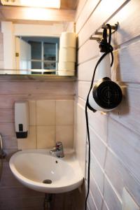 a bathroom with a sink and a hair dryer on the wall at Villa Kurpitsa at MESSILA ski & camping in Hollola