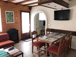 - une salle à manger avec une table, des chaises et une télévision dans l'établissement Appt. ÄISCHER, à Wilwerwiltz