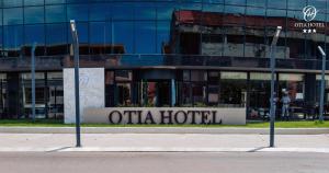 uma placa de hotel em frente a um edifício de vidro em OTIA HOTEL em Maputo