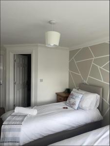 a bedroom with a large white bed and a ceiling at Yew Tree Court in Heswall