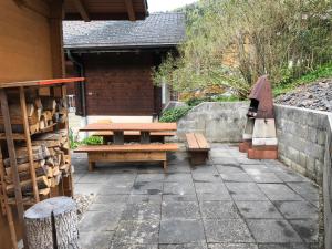 un patio con bancos, una mesa y una pared en bella Romantica en Brunig