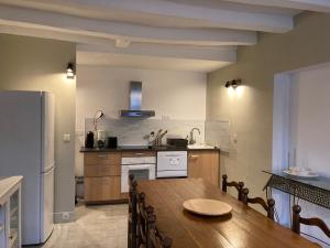 cocina con mesa de madera y nevera en Le Loft - Chenonceaux - 3 étoiles, en Chenonceaux