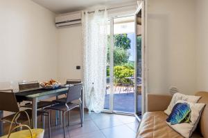 een woonkamer met een tafel en een glazen deur bij Appartamento Verdemare in Diano Marina