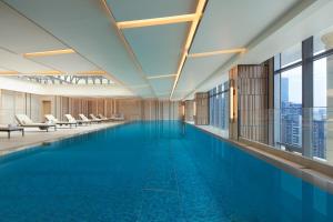 a swimming pool in a building with a view of the city at Courtyard by Marriott Foshan in Foshan