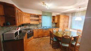 una cucina con armadi in legno e tavolo con sedie di Rooms and apartments Biš 
