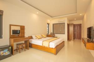West Life Bungalow Phu Quoc في فو كووك: غرفة نوم فيها سرير وتلفزيون