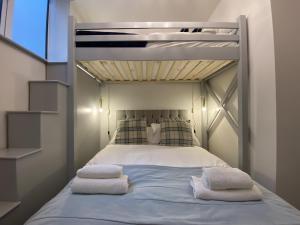 a bedroom with a bunk bed with towels on it at Roman Bath View in Bath