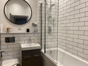 a bathroom with a sink and a shower and a mirror at Roman Bath View in Bath +45 photos