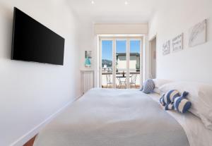 um quarto branco com uma cama e uma televisão de ecrã plano em Ag Sorrento Rooms em Sorrento