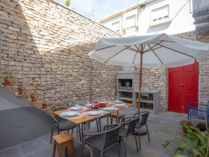 ein Tisch mit Stühlen und einem Sonnenschirm auf einer Terrasse in der Unterkunft Casa do Poeta in Figueira da Foz