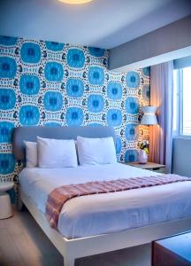 a bedroom with a large bed with a blue wall at Trópica Beach Hotel in San Juan