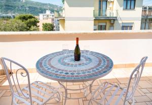 uma garrafa de vinho de vidro sentada numa mesa na varanda em Ag Sorrento Rooms em Sorrento