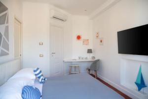 a bedroom with a bed and a flat screen tv at Ag Sorrento Rooms in Sorrento