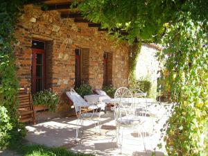 un patio con sillas y una mesa frente a un edificio en Hotel Boutique Condes Fúcares, en Almadén