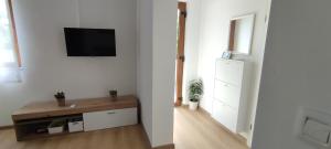 Dieses weiße Zimmer verfügt über einen TV an der Wand. in der Unterkunft Apartment Bella in Pula