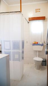 a bathroom with a toilet and a shower at Kusini House & Campsite in Eldoret