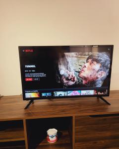 a flat screen tv sitting on top of a wooden table at Bali Residence Impian Raudah in Melaka