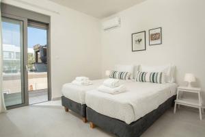 Un dormitorio blanco con una cama grande y una ventana en Cozy Apartment in the heart of Rhodes City Center, en Rodas