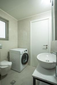 Baño blanco con aseo y lavamanos en Cozy Apartment in the heart of Rhodes City Center, en Rodas