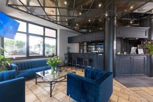 a restaurant with a bar with blue chairs and a table at Hotel Stadt Gütersloh in Gütersloh