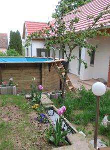 een achtertuin met een zwembad en een huis bij Müllers Wellness Ferienhaus in Döbrököz