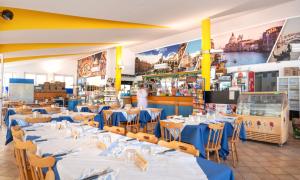 un restaurante con mesas y sillas azules y un bar en Camping Atlanta & Mediterraneo Family Village, en Sottomarina