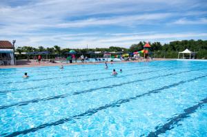 a group of people swimming in a large swimming pool at Camping Atlanta & Mediterraneo Family Village in Sottomarina