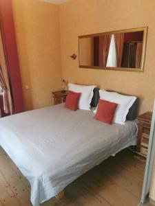 1 dormitorio con cama blanca y almohadas rojas en KaunasInn, en Kaunas