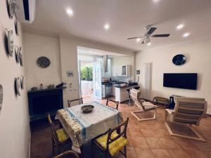 uma sala de estar com mesa e cadeiras e uma cozinha em Be Your Home - Maria's Cozy House&Garden em Santa Marinella
