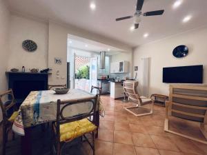 cocina y sala de estar con mesa y sillas en Be Your Home - Maria's Cozy House&Garden, en Santa Marinella