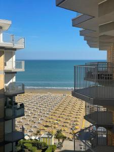 - une vue sur une plage avec des parasols et l'océan dans l'établissement RESIDENCE CENTRO COMMERCIALE - WALTERIGATO Apartments SOLO PER FAMIGLIE, à Lido di Jesolo