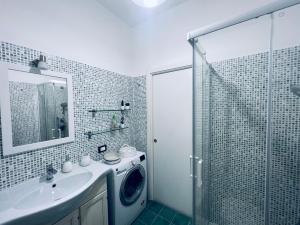 a bathroom with a washing machine next to a shower at Be Your Home - Maria's Cozy House&Garden in Santa Marinella