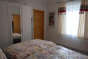 1 dormitorio con cama y espejo en Müllers Wellness Ferienhaus, en Döbrököz