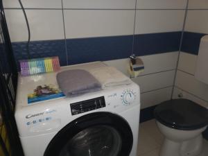 een wasmachine in een badkamer met een toilet bij Müllers Wellness Ferienhaus in Döbrököz