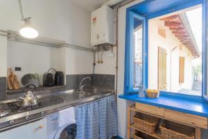 une cuisine avec un évier et une fenêtre dans l'établissement Deriva Apartment on Careno's Beach by Rent All Como, à Nesso